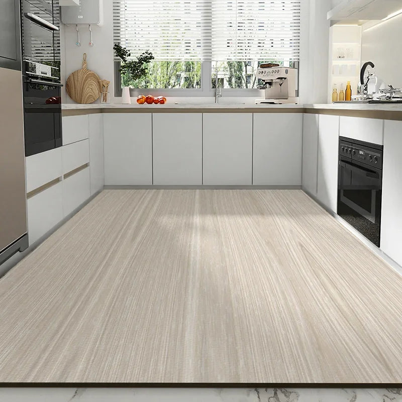 La cuisine moderne avec des armoires blanches, des plans de travail en marbre, un grand évier et un sol en bois clair crée un espace lumineux et épuré.