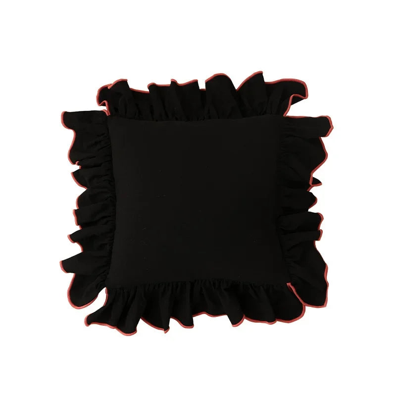 Coussin noir avec bord de couleur rouge vif.