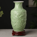 Vase en céramique de couleur vert pâle, avec un décor en relief représentant des poissons et des fleurs.