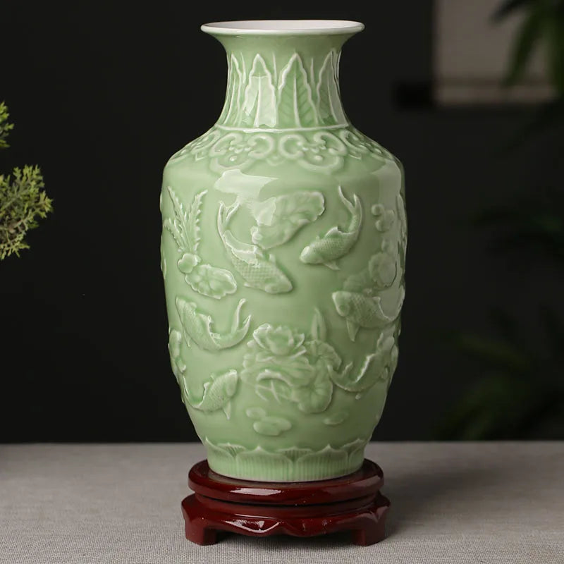 Vase en céramique de couleur vert pâle, avec un décor en relief représentant des poissons et des fleurs.