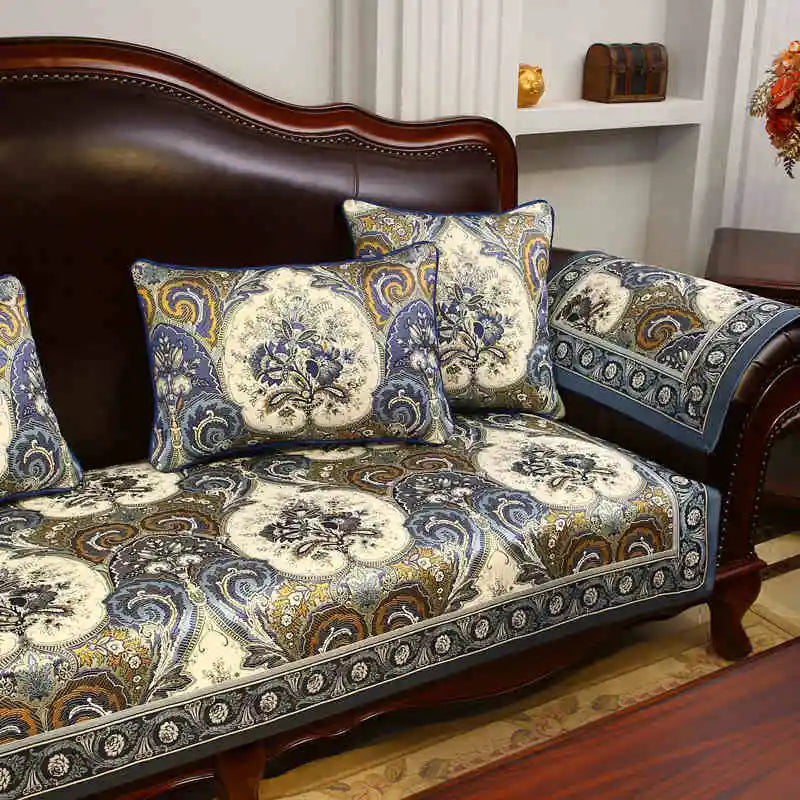 Un canapé en bois foncé avec des coussins décorés de motifs floraux multicolores, créant une atmosphère chaleureuse et élégante dans la pièce.