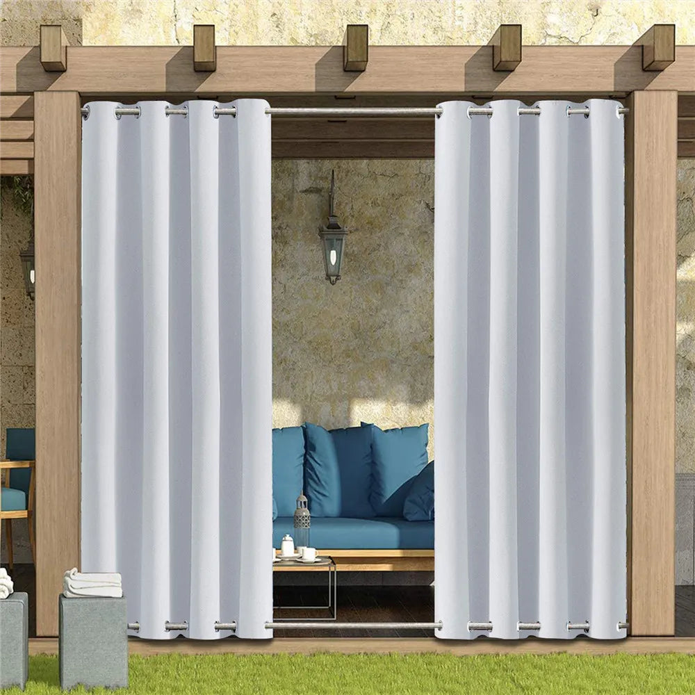 Des rideaux de couleur claire, délicatement accrochés à une structure extérieure en bois d'un éco-hôtel. Ces rideaux offrent une ombre apaisante sur un ensemble de mobilier d'extérieur comprenant des chaises confortables. L'arrière-plan présente une vue relaxante, s'ajoutant à l'ambiance de station balnéaire de cette image.