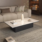 table basse moderne minimaliste noir blanche surface lisse tapis branches tasses livres coussins