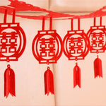 décoration mariage chinois motif double bonheur rouge or papier texturé éléments ajourés pompons rouges