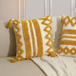 Des coussins aux motifs géométriques jaunes et blancs, avec des franges, apportent une touche décorative et chaleureuse à ce coin de pièce.