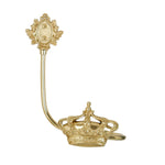 Objet décoratif doré en forme de couronne ornée de motifs floraux sur un bâton.