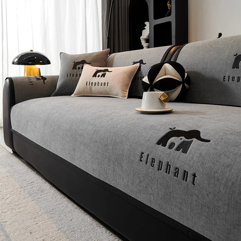 Le canapé gris confortable avec les coussins imprimés d'éléphants, la lampe de sol et la tasse sur la table basse créent une ambiance chaleureuse et relaxante dans cette pièce.