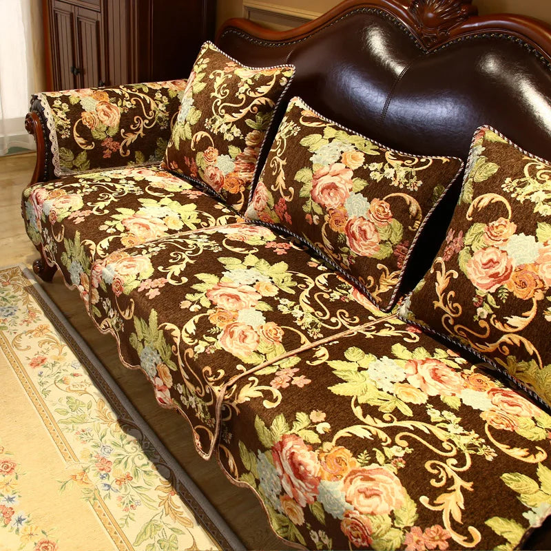 Canapé vintage en cuir brun avec des motifs de roses et de feuilles sur les coussins, créant une atmosphère luxueuse et élégante.