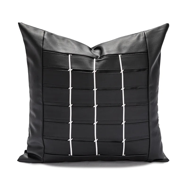 Coussin décoratif noir en cuir avec motif géométrique en blanc.