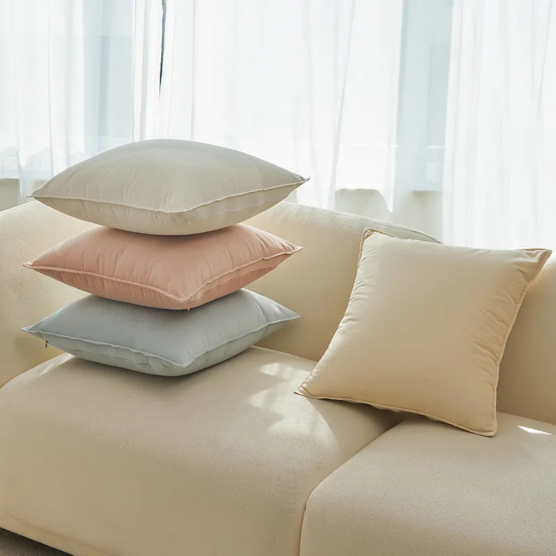 Coussin décoratif multicolore sur un canapé dans un salon lumineux.