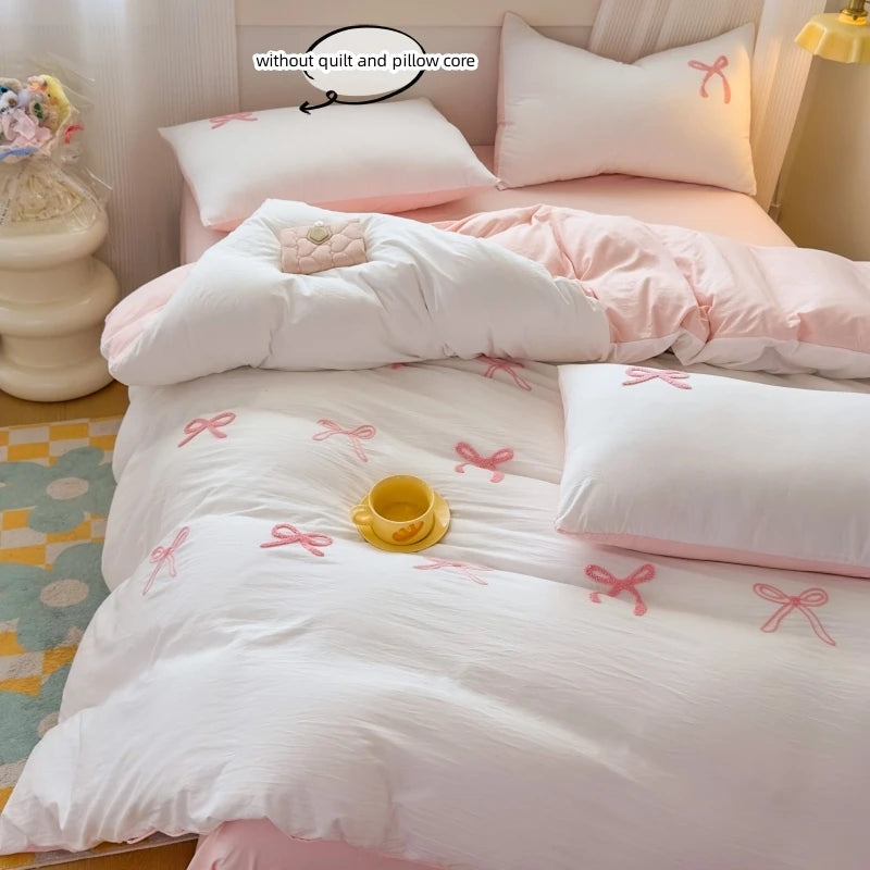 Détail broderie nœud papillon sur housse de couette rose