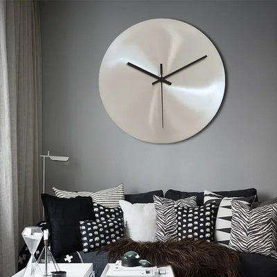 Horloge murale industrielle argentée minimaliste accrochée sur un mur de salon moderne