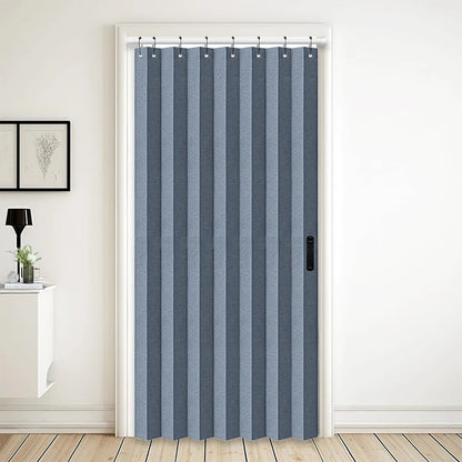 Rideau accordéon bleu gris installé dans une embrasure de porte, utilisé comme cloison souple pour séparer deux espaces de vie avec élégance.