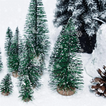 Composition décorative avec mini sapins de différentes tailles sur une table