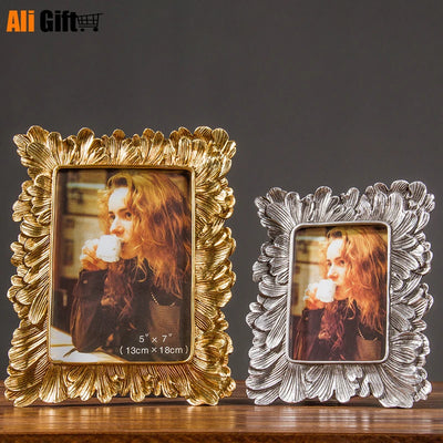 Cadre photo argent vintage avec motifs floraux sur fond blanc