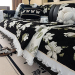 Un élégant ensemble de literie noir et blanc orné de fleurs et de papillons, créant une atmosphère sophistiquée et chaleureuse dans la chambre.