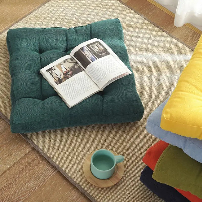 Coussin de sol carré en velours côtelé orange dans un jardin