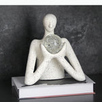statue décorative personnage humain sphère transparente motifs internes neige cristaux blanc taches noires.texture granuleuse