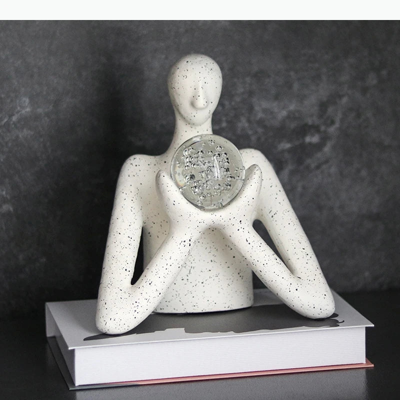 statue décorative personnage humain sphère transparente motifs internes neige cristaux blanc taches noires.texture granuleuse