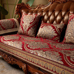 Un canapé en bois sculpté avec des motifs floraux décoratifs, des coussins et une couverture en rouge et or, créant une atmosphère luxueuse et élégante.