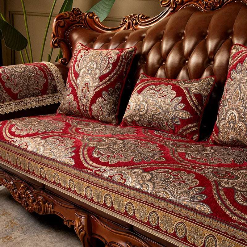 Un canapé en bois sculpté avec des motifs floraux décoratifs, des coussins et une couverture en rouge et or, créant une atmosphère luxueuse et élégante.