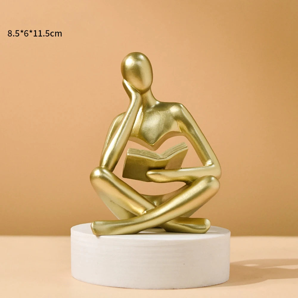 statue décorative résine figure humaine assise livre ouvert beige clair doré textures abstraites moderne