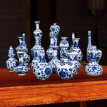 Assortiment de vases et de pots en céramique de style chinois avec des motifs floraux bleus et blancs, disposés sur une table en bois.