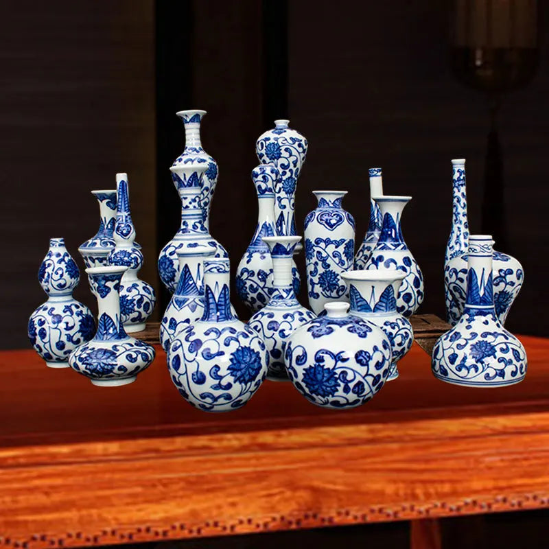 Assortiment de vases et de pots en céramique de style chinois avec des motifs floraux bleus et blancs, disposés sur une table en bois.