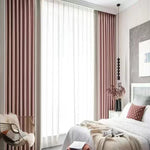 Rideau à ruflette rose et beige installé dans une chambre moderne aux tons neutres, apportant chaleur et douceur.