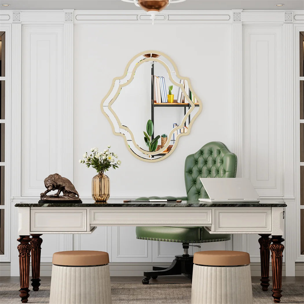 Un bureau élégant dans un style classique avec un miroir ornemental doré, des ornements décoratifs et un fauteuil en cuir vert, créant une atmosphère sophistiquée et raffinée.