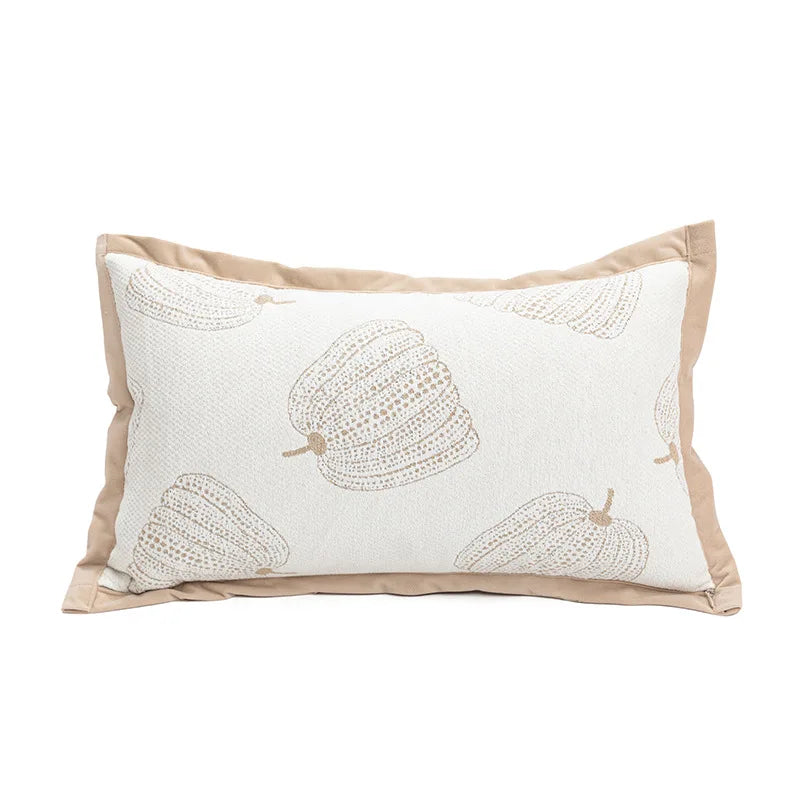 Coussin décoratif rectangulaire beige et blanc avec un motif de poires ornées de détails en relief.