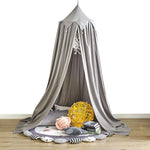 Lit baldaquin gris élégant avec décoration murale et accessoires confortables, créant un espace cocooning intime et relaxant.