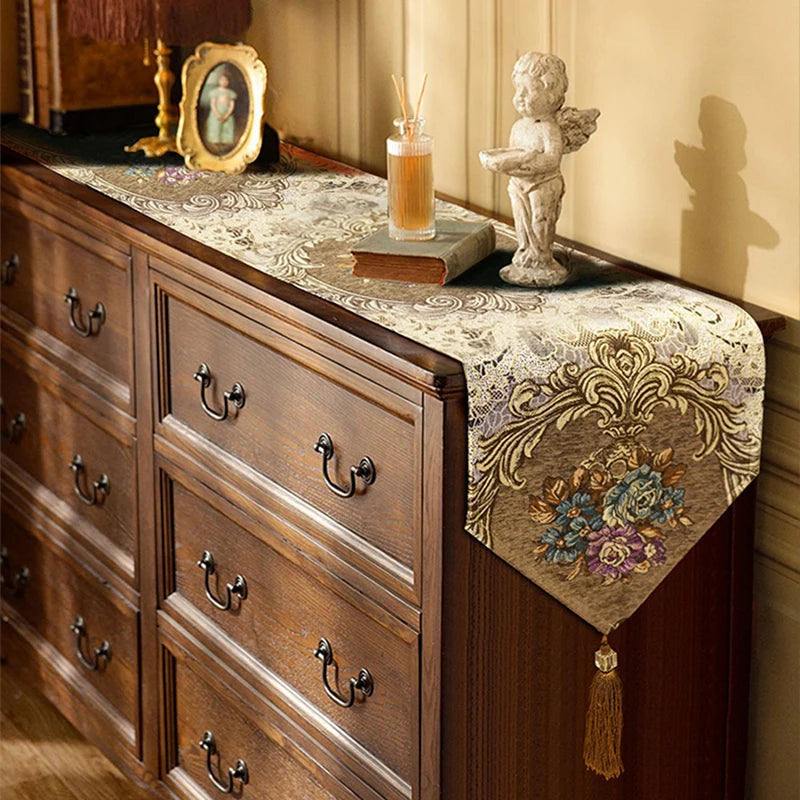 Ancien meuble en bois finement ouvragé, avec des tiroirs et des décorations ornées, surmonté de divers objets de décoration vintage.