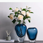 vase moderne transparent bleu foncé bulles fleurs artificielles feuilles bougie minimaliste