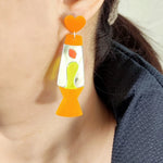 Détail des boucles d'oreilles acryliques forme lampe lave