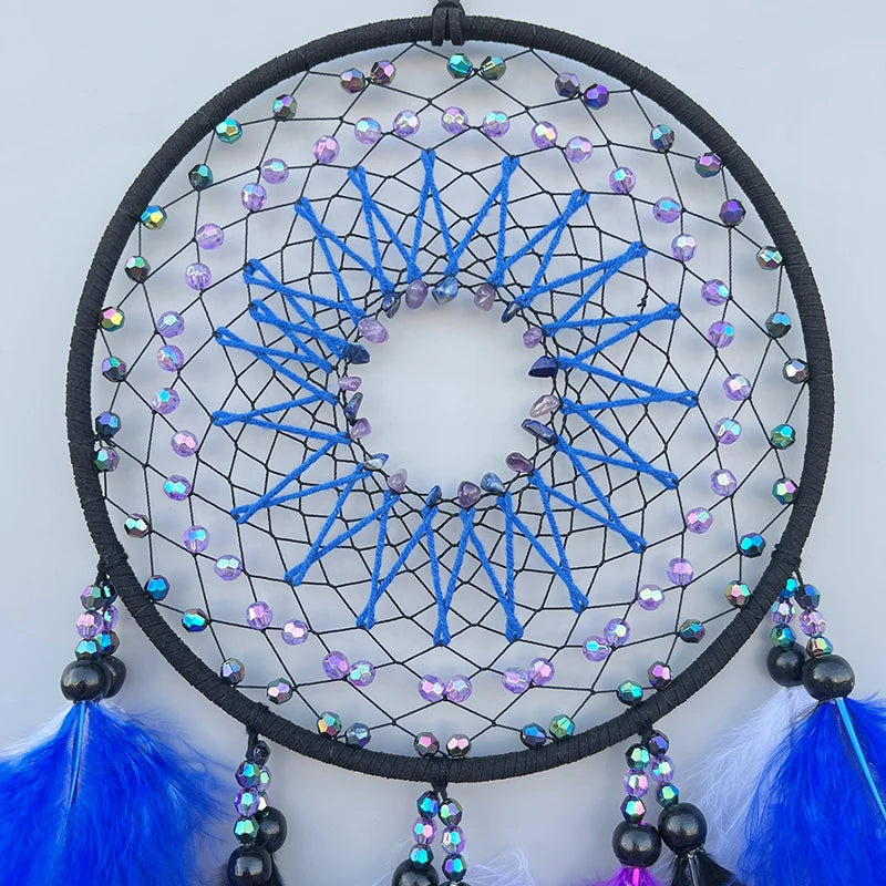 Attrape-rêves rond avec motifs géométriques bleus et violets, décoré de perles multicolores et de plumes bleues.