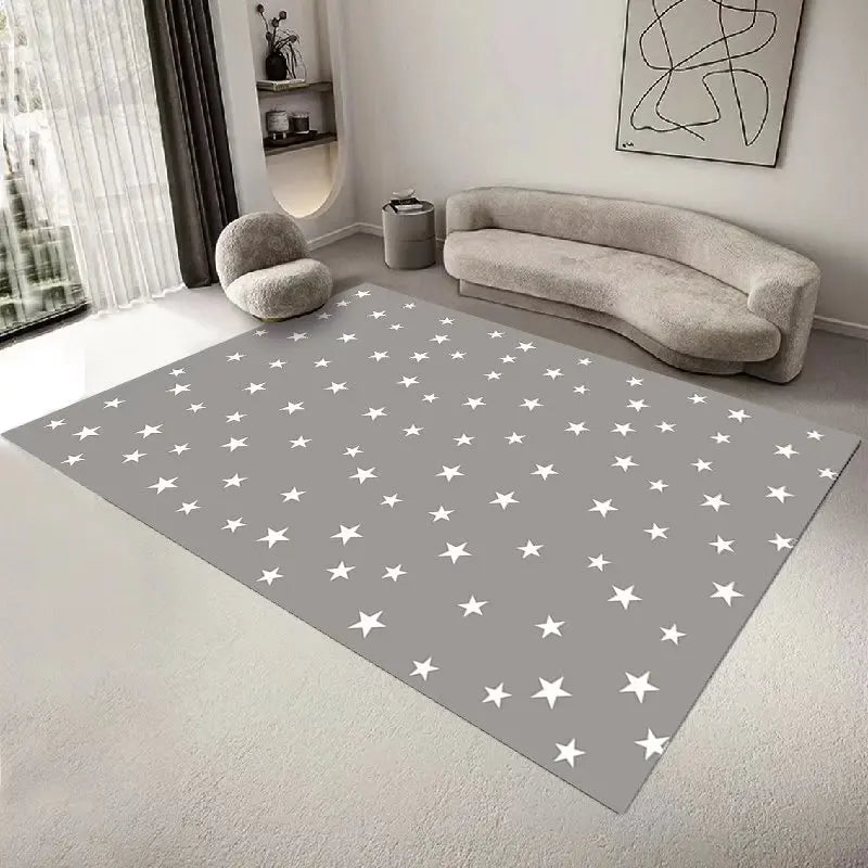 Le tapis au sol présente un motif de nombreuses étoiles blanches sur un fond gris, créant un style épuré et moderne dans cette pièce avec un canapé gris et d'autres éléments de décoration.