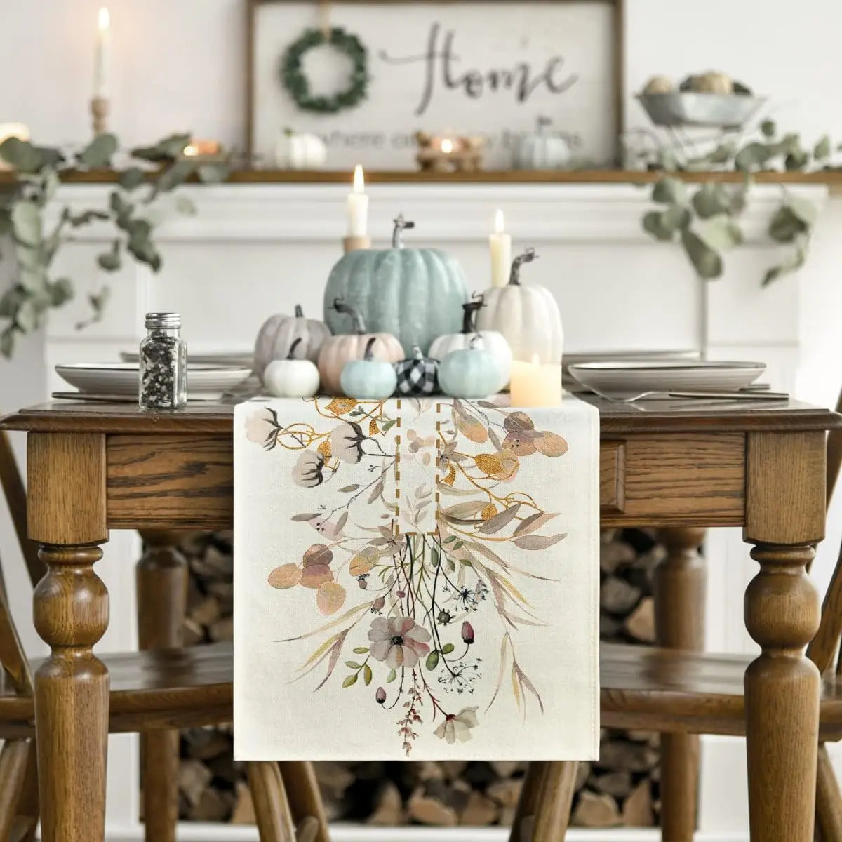 Cette image décore une table de salle à manger avec des arrangements de citrouilles, de bougies et d'un chemin de table orné de fleurs séchées, créant une ambiance automnale chaleureuse et apaisante.
