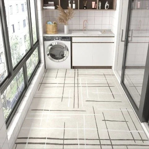 Une salle de lavage moderne, spacieuse et bien aménagée, avec des carreaux de sol motifs géométriques blancs et gris, une laveuse-sécheuse blanche et des étagères de rangement.