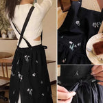 tablier cuisine noir fleurs blanches coton polyester plissé croisé dos poches classique imperméable