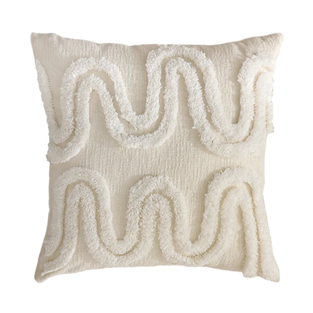 Coussin décoratif moelleux avec un motif abstrait blanc et beige.