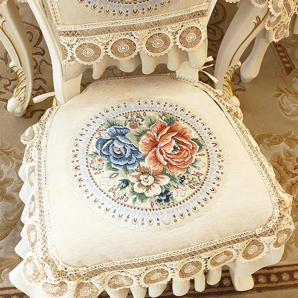 Coussin décoratif vintage avec magnifique broderie florale en teintes douces, entouré de dentelle délicate, créant une atmosphère élégante et raffinée.