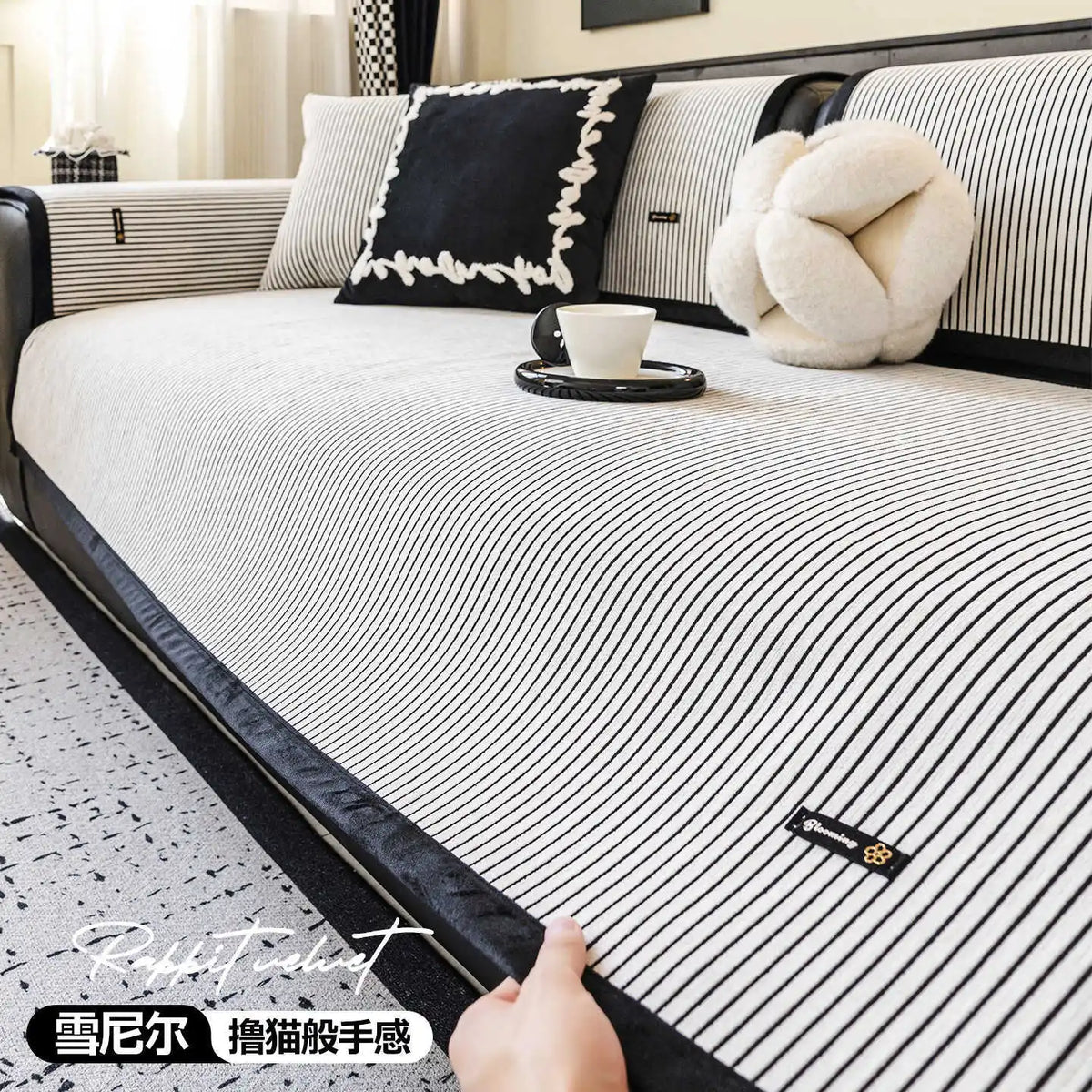 Une élégante chambre de style minimaliste avec des accents noirs et blancs, des coussins décoratifs et une tasse de café sur le lit.