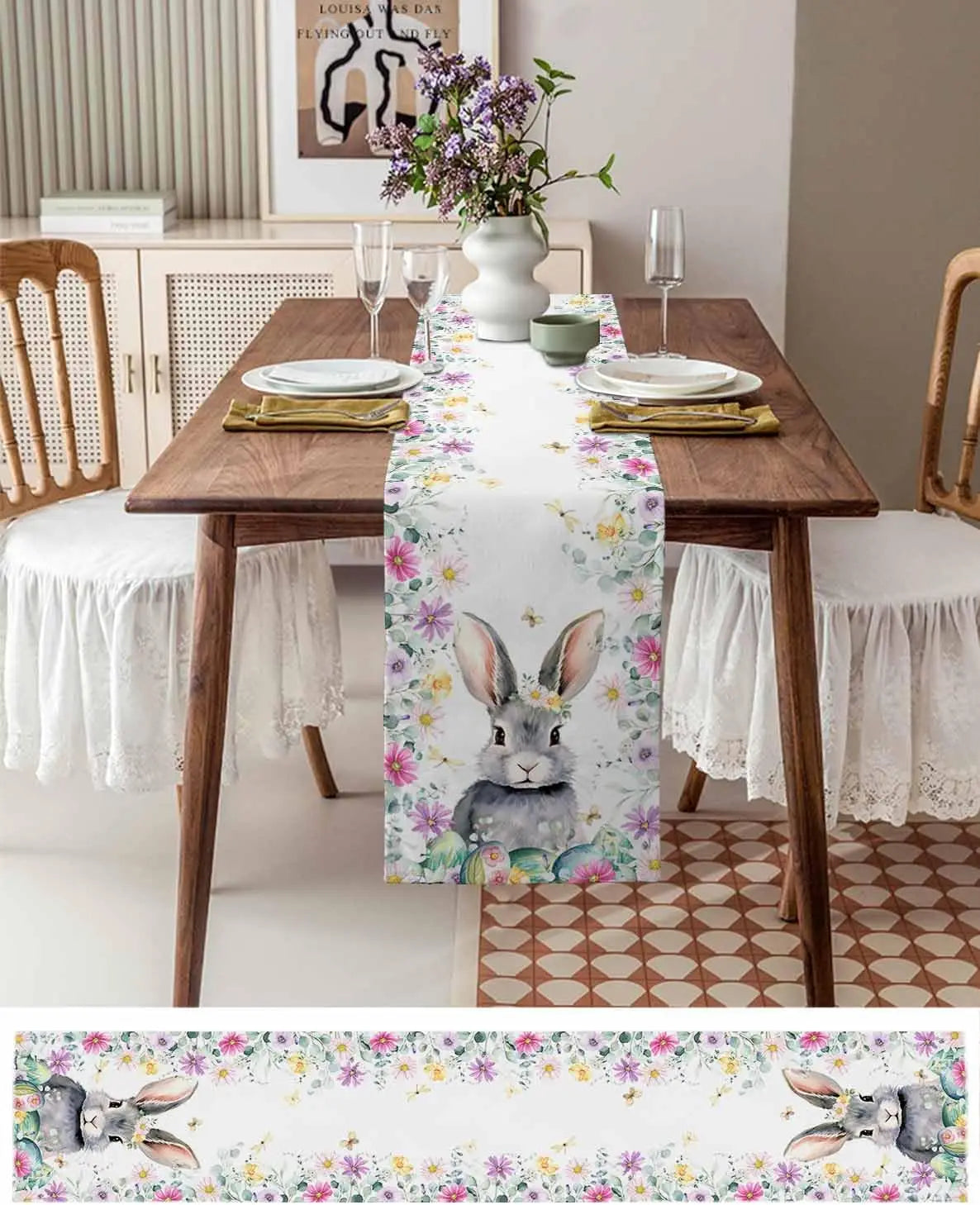Une table à manger en bois rustique avec une nappe ornée de lapins et de fleurs colorées, accompagnée de chaises blanches, d'un bouquet de fleurs dans un vase et de vaisselle élégante, créant une ambiance chaleureuse et printanière.