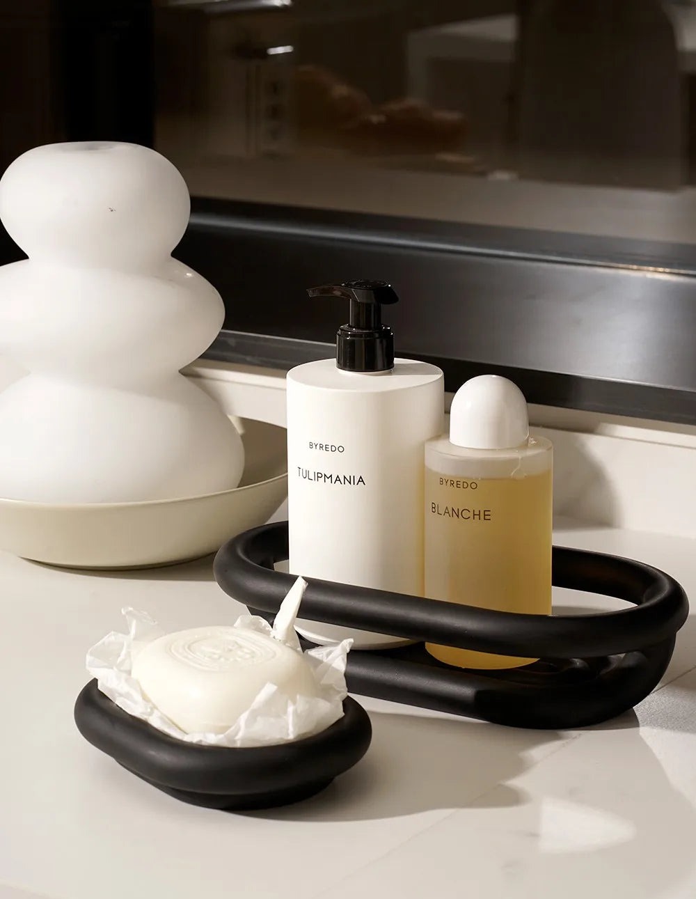 plateau noir savon blanc flacon cosmétique sculpture blanche livre hermes parfum diffuseur bouchon noir