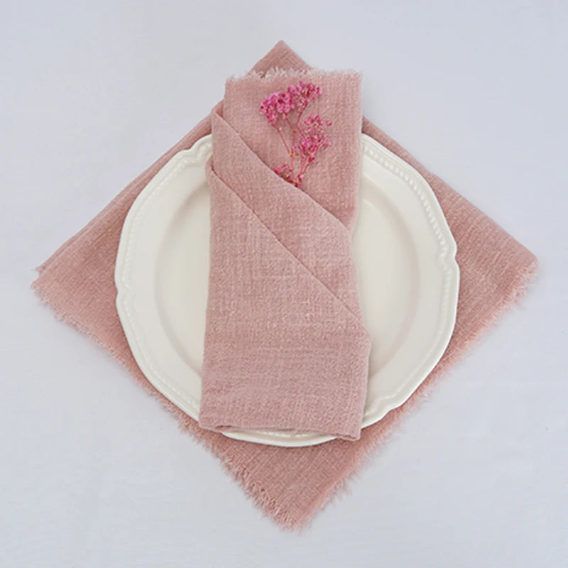Une nappe en tissu rose pale avec une décoration florale, posée sur une assiette blanche.