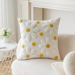 Détail du motif fleur brodé géométrique sur coussin tufté beige