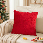 Coussin décoratif moelleux de couleur rouge vif, posé sur un canapé dans une pièce de style vintage aux tons beiges et décorée pour Noël avec un sapin et des objets de décoration.