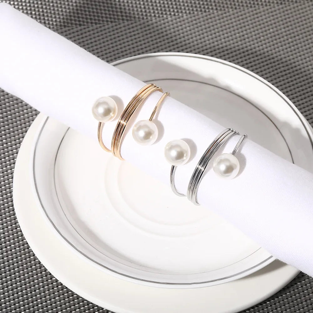Des bracelets en argent et en or ornés de perles élégantes sur une assiette blanche.