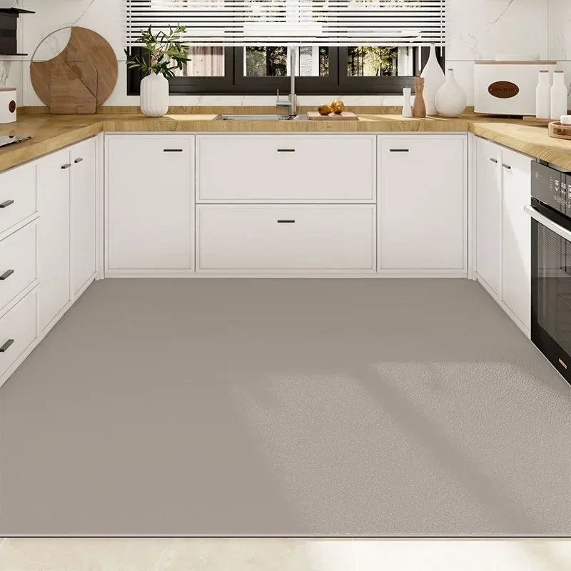 Une cuisine moderne et épurée avec des meubles blancs, un plan de travail en bois clair et une fenêtre offrant une vue sur l'extérieur.